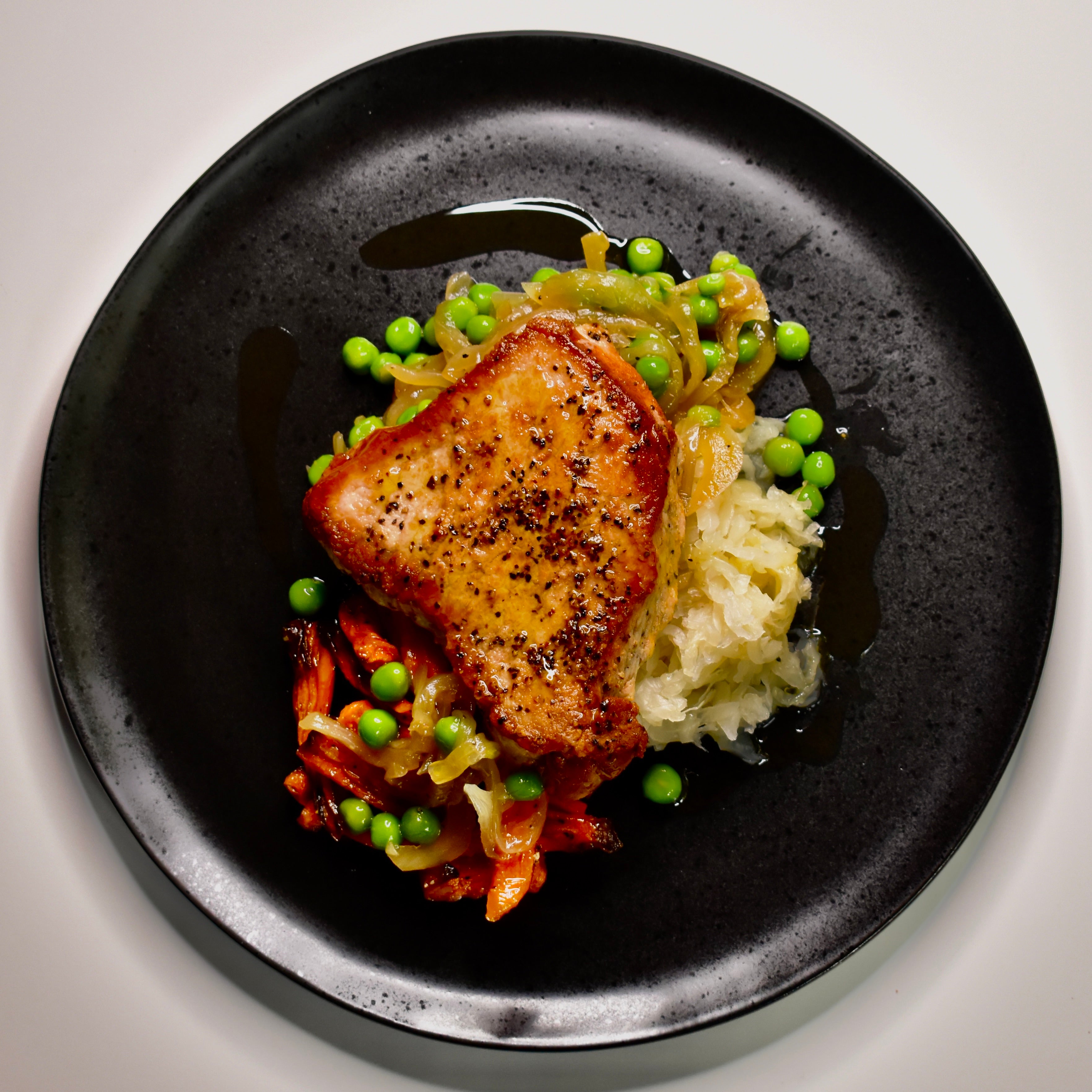 Roasted Pork Loin with Sauerkraut, Sautéed Onions & Green Peas, and Roasted Carrots